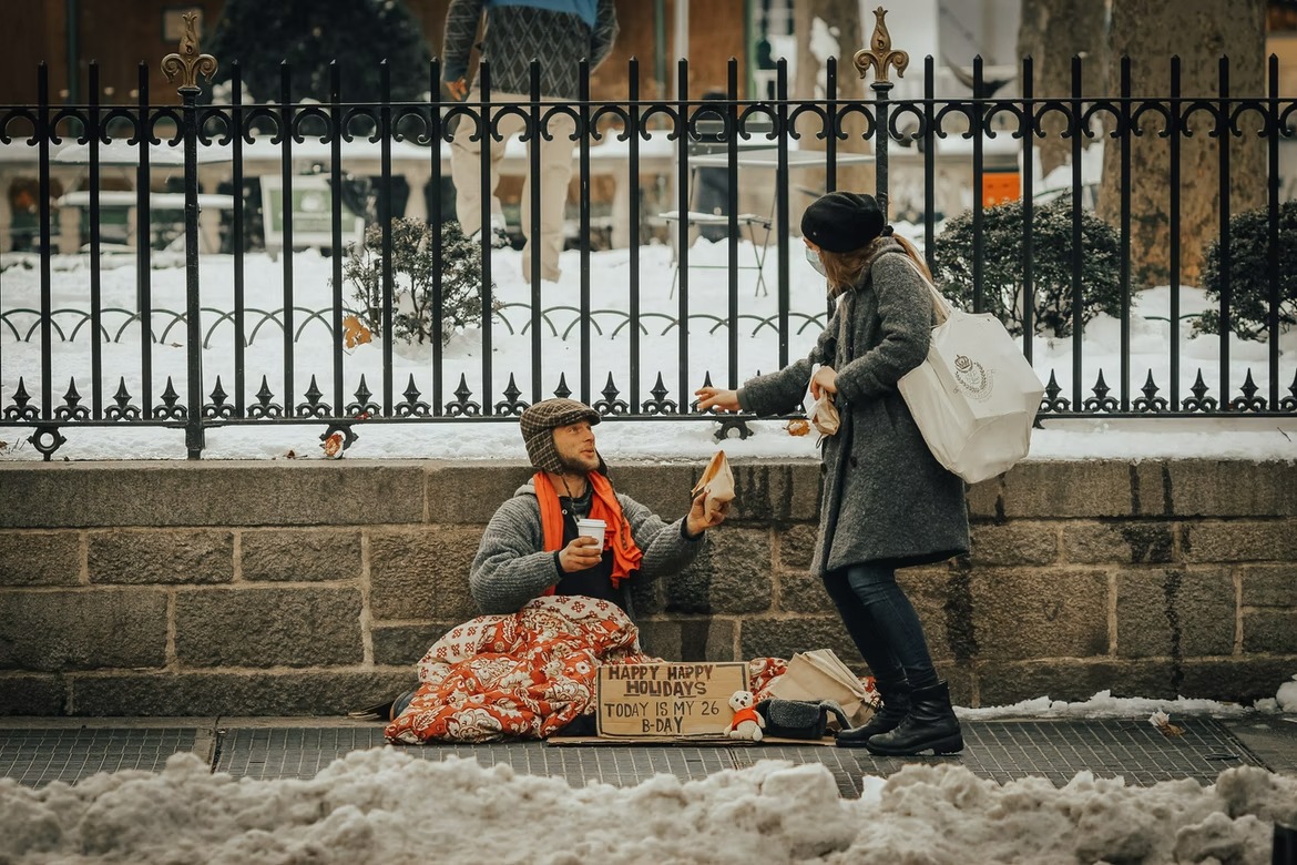 Woman Giving Food to Homeless